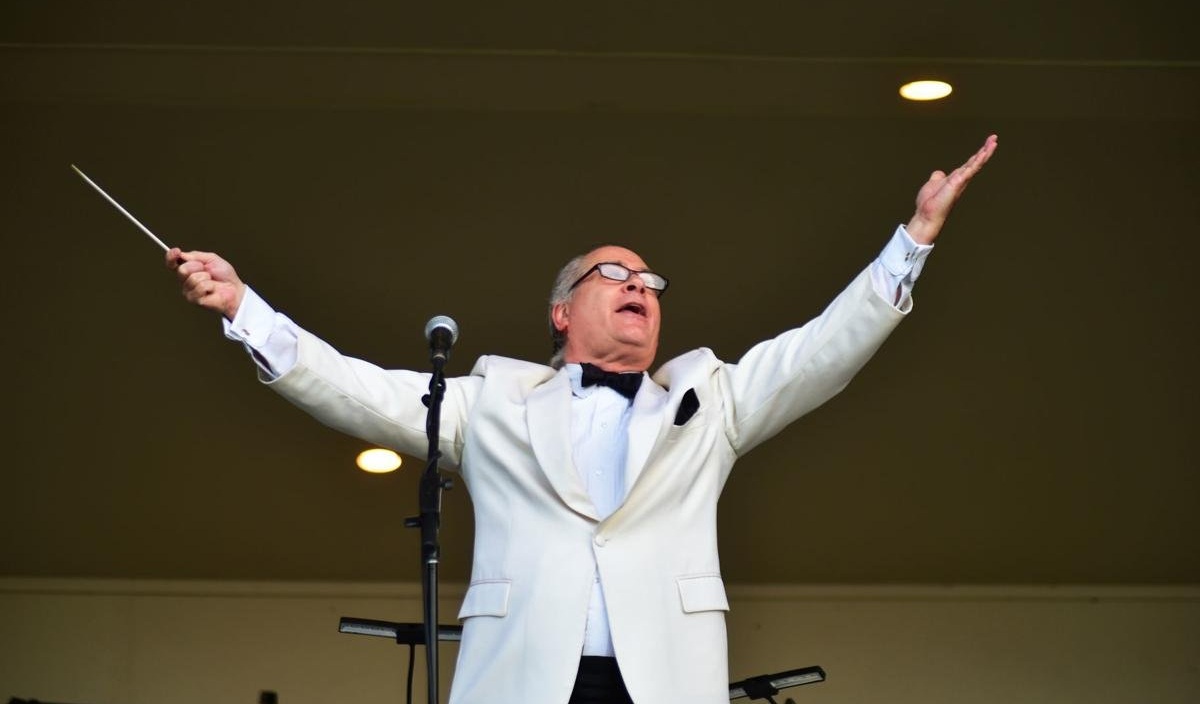 Charles Peltz conducting with arms raised